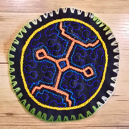 Hand-embroidered Shipibo textile in deep blue tones. A small round accent perfect for home decor, boho tables, or as an artisanal coaster.